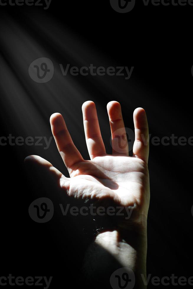 uomo mano su Esprimere a gesti nel il ombre, buio sfondo foto