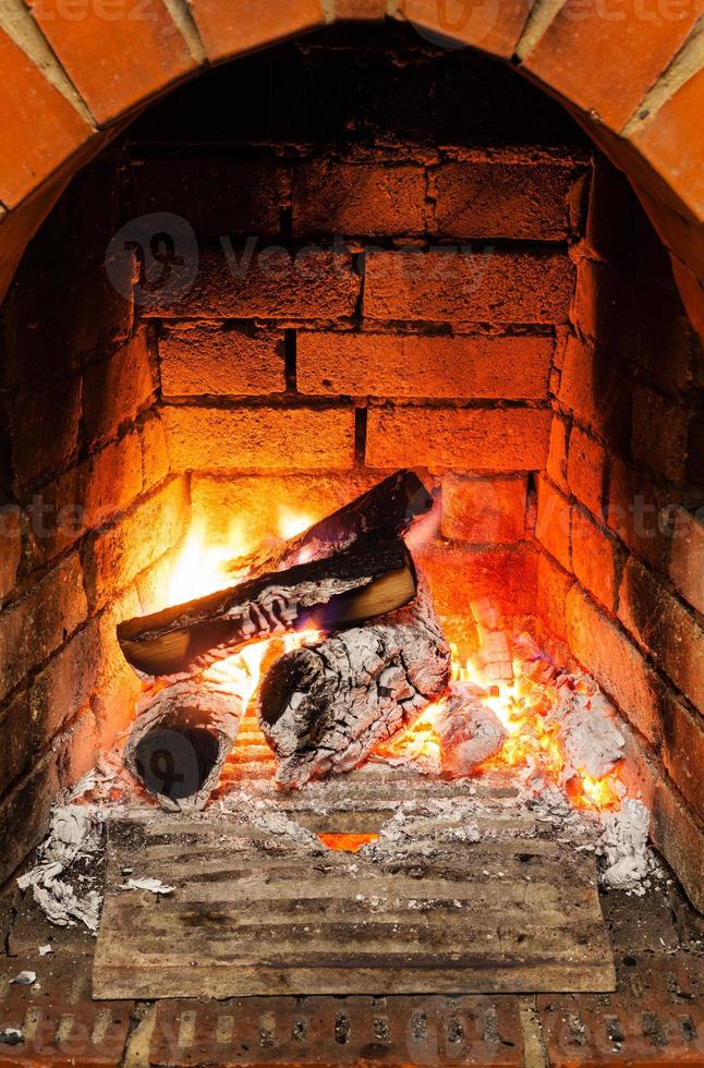 cenere, carbone e ardente di legno logs nel camino foto