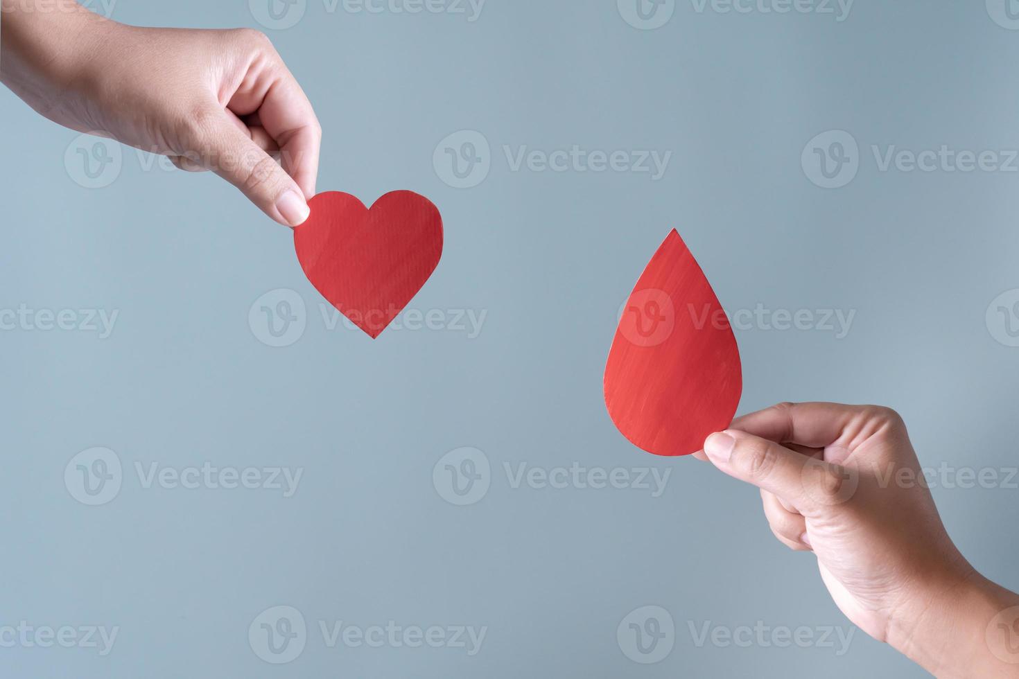 sangue donazione o chirurgia concetto. umano Tenere sangue cartello e un' rosso cuore forma. foto