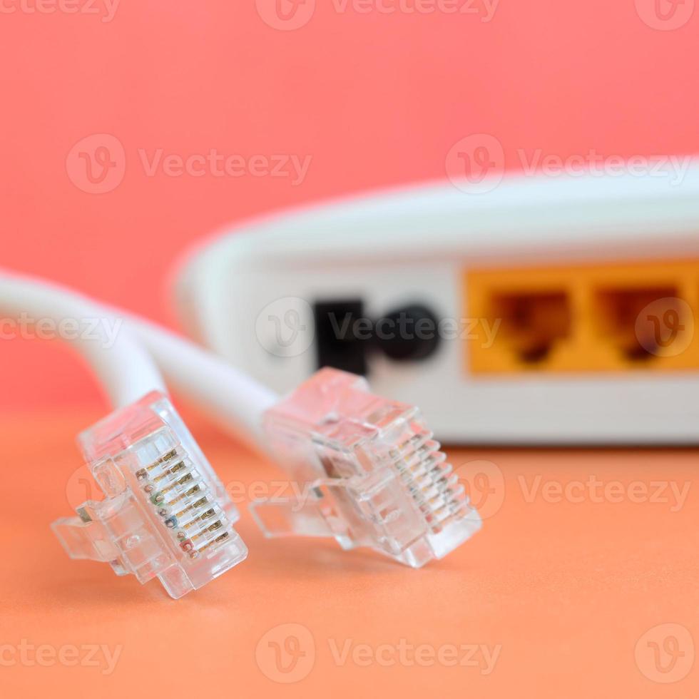 Internet router e Internet cavo spine menzogna su un' luminosa arancia sfondo. elementi necessario per Internet connessione foto