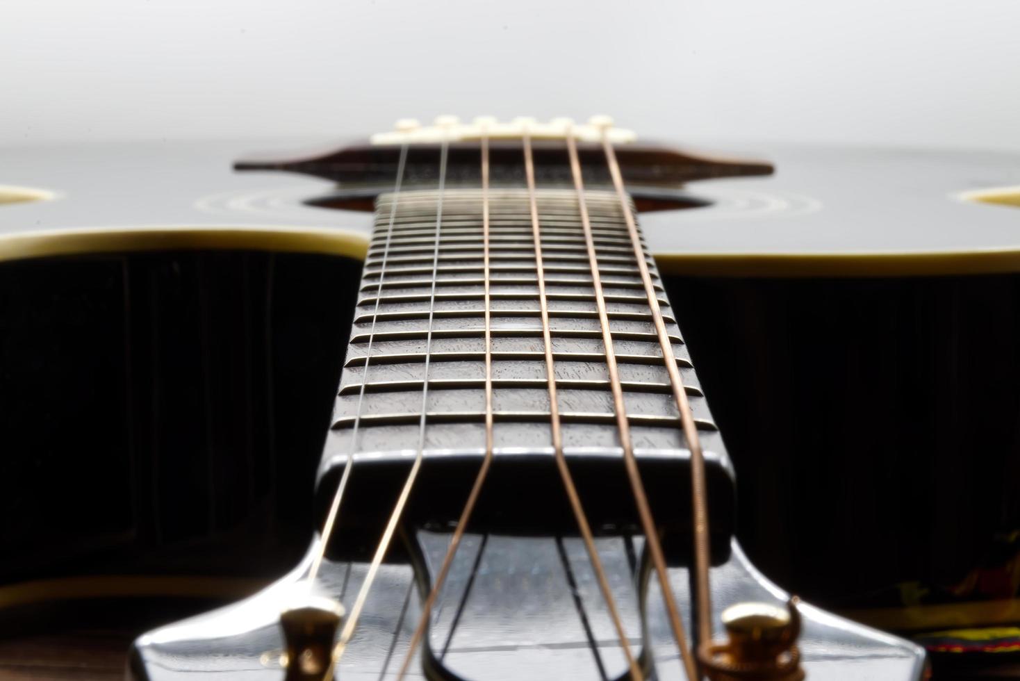 acustico nero chitarra isolato su bianca sfondo, messa a fuoco su tastiera foto