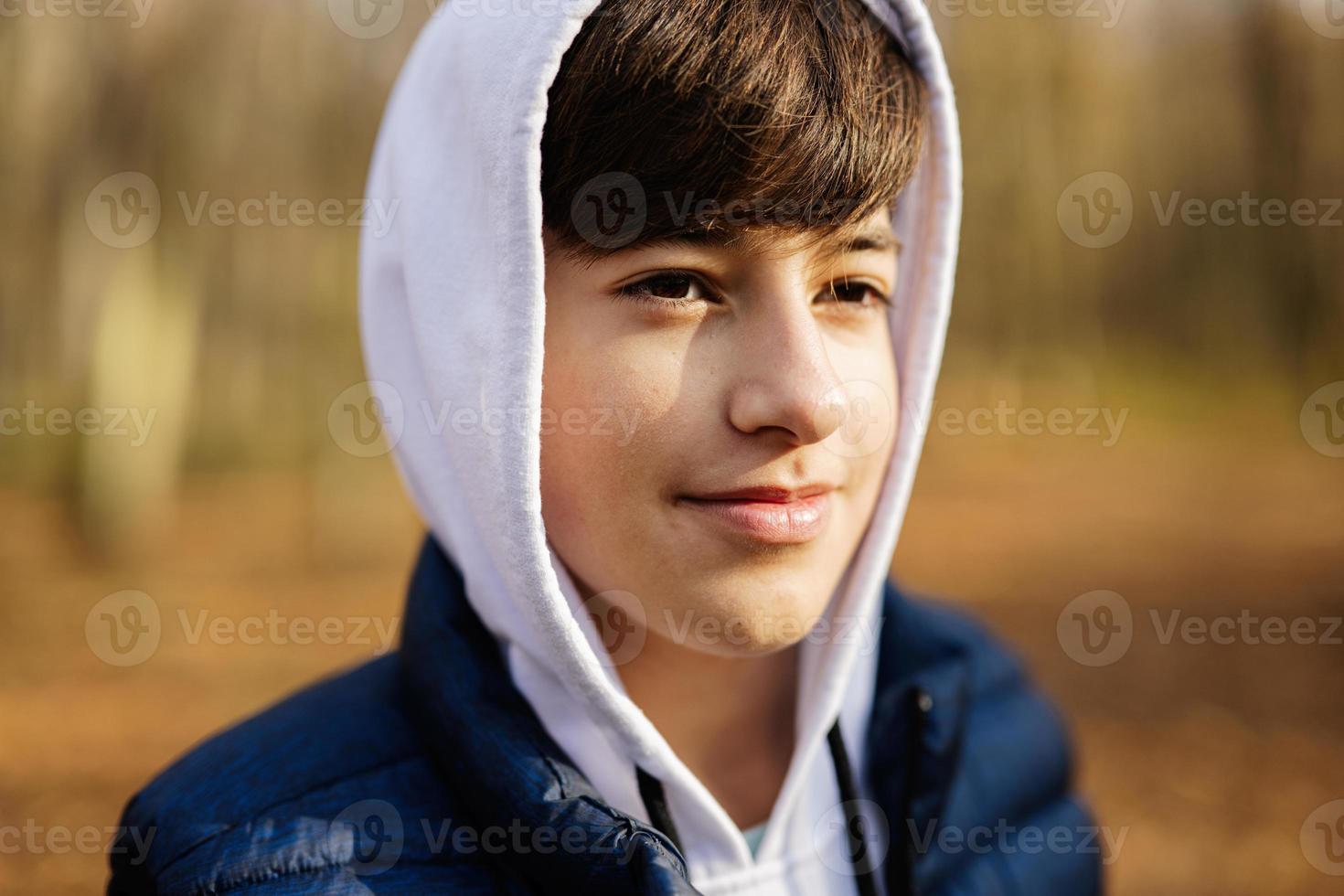 vicino su ritratto di adolescente ragazzo nel felpa con cappuccio e senza maniche veste a autunno foresta. foto