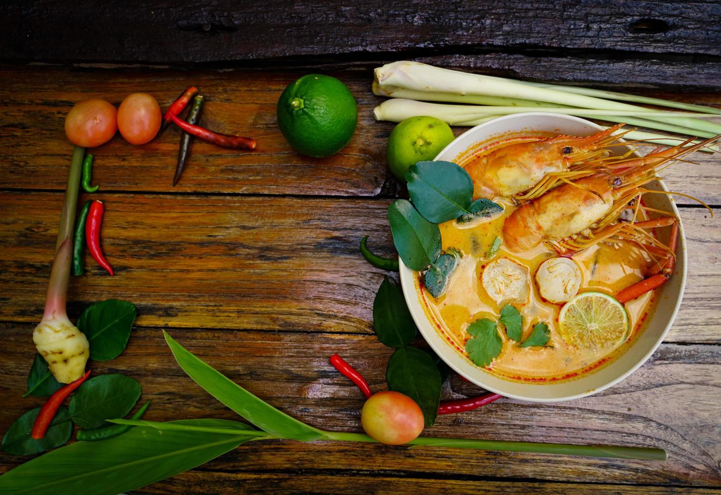 tom yum kung nel un' tazza su un' di legno pavimento, tom yum kung è anche il nazionale piatto di Tailandia. e è un' cibo quello è famoso tutti al di sopra di il mondo. foto