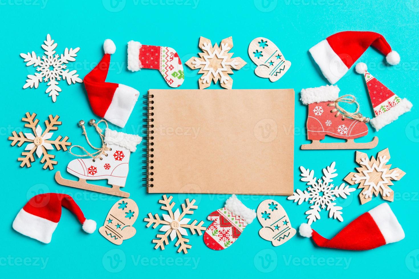 superiore Visualizza di taccuino con Natale decorazioni e Santa cappelli su blu sfondo. contento vacanza concetto foto