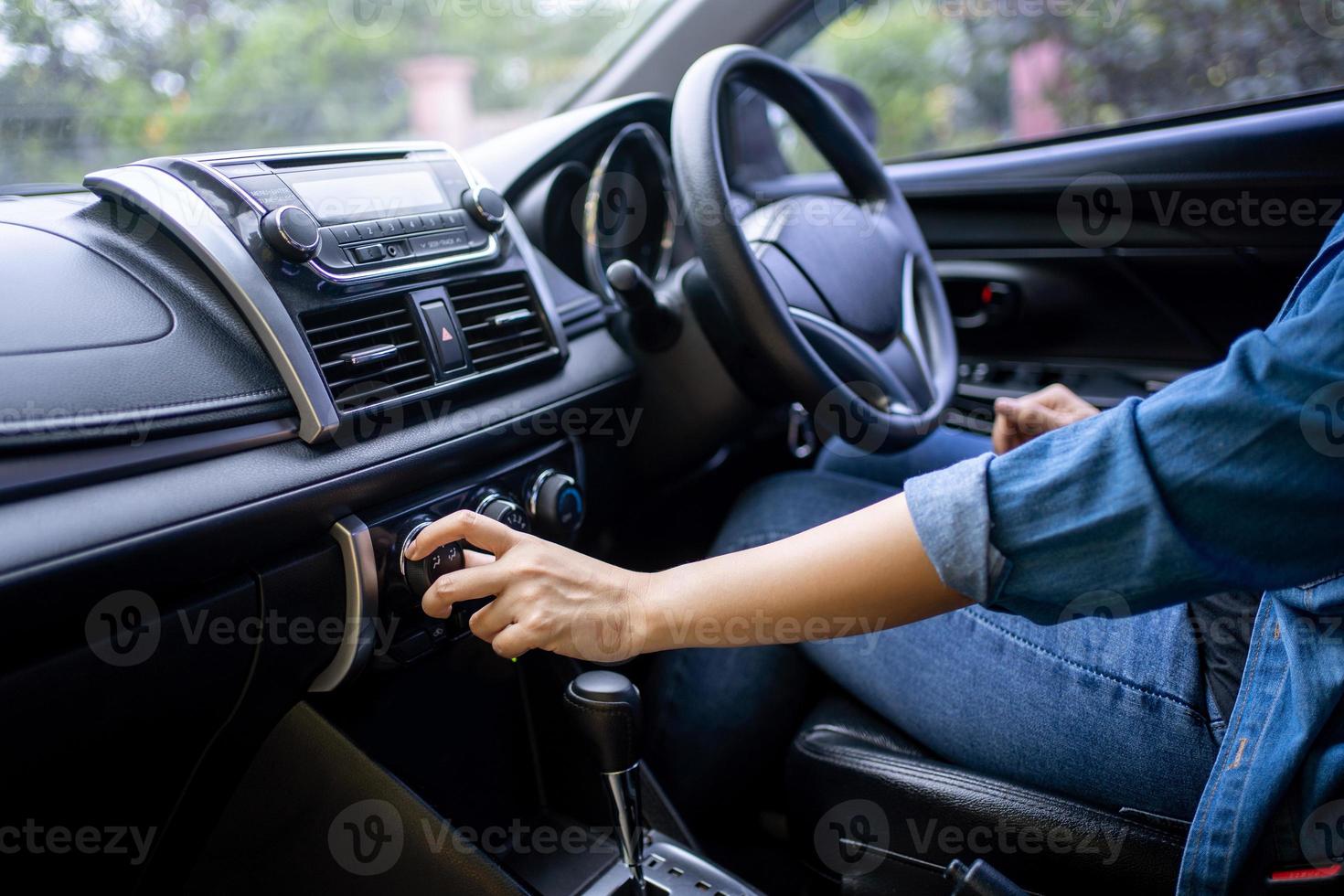 mano di donna svolta su auto aria condizione sistema, pulsante su pannello di controllo nel auto pannello, auto auto aria condizione foto