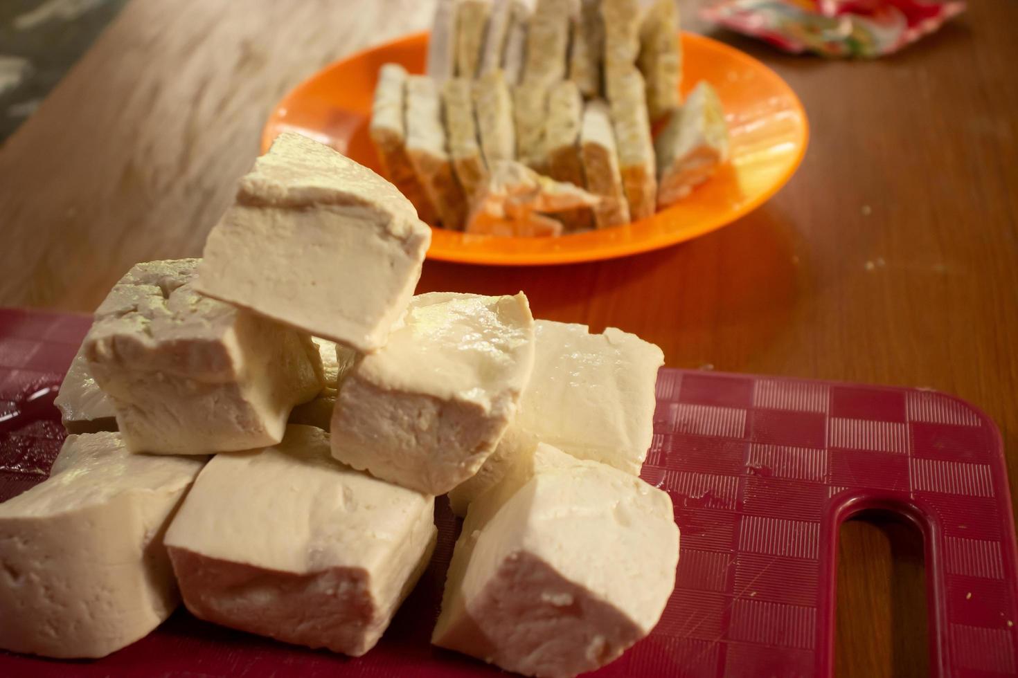 tempe e tofu nel loro rispettivo contenitori su un' cioccolato tavolo foto