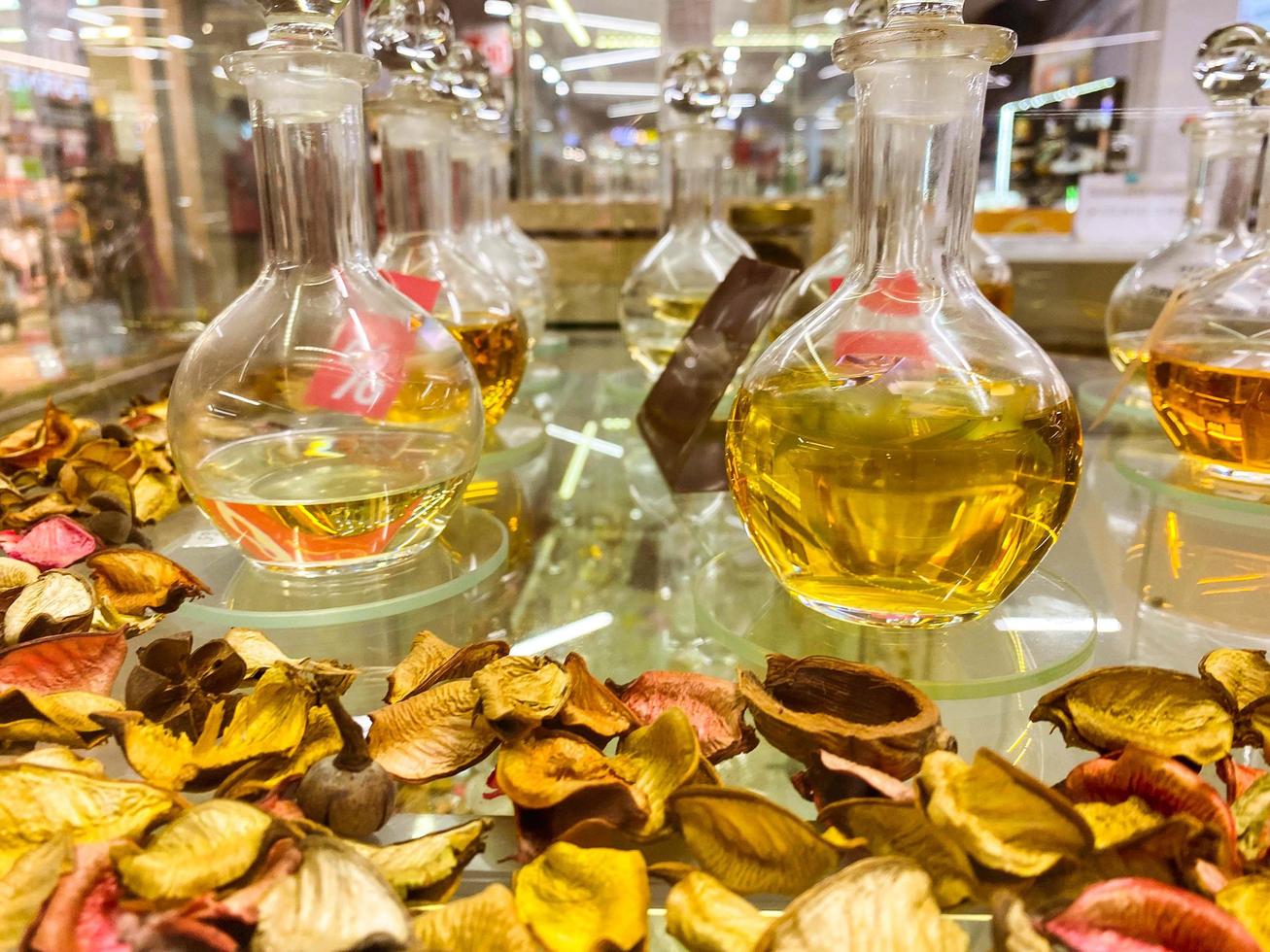 profumi nel trasparente boccette. miscela di fragranze, profumo essenza, laboratorio con liquidi nel fiaschi su fiore petali. decorato vetrina con profumo foto