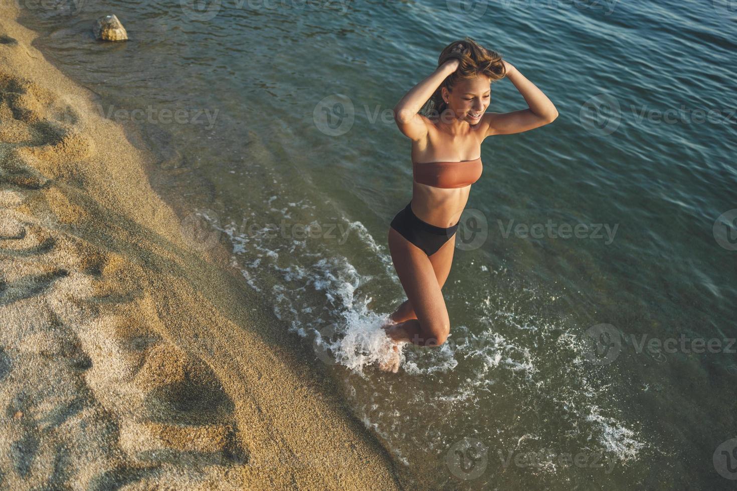 adolescente ragazza a piedi a il spiaggia foto