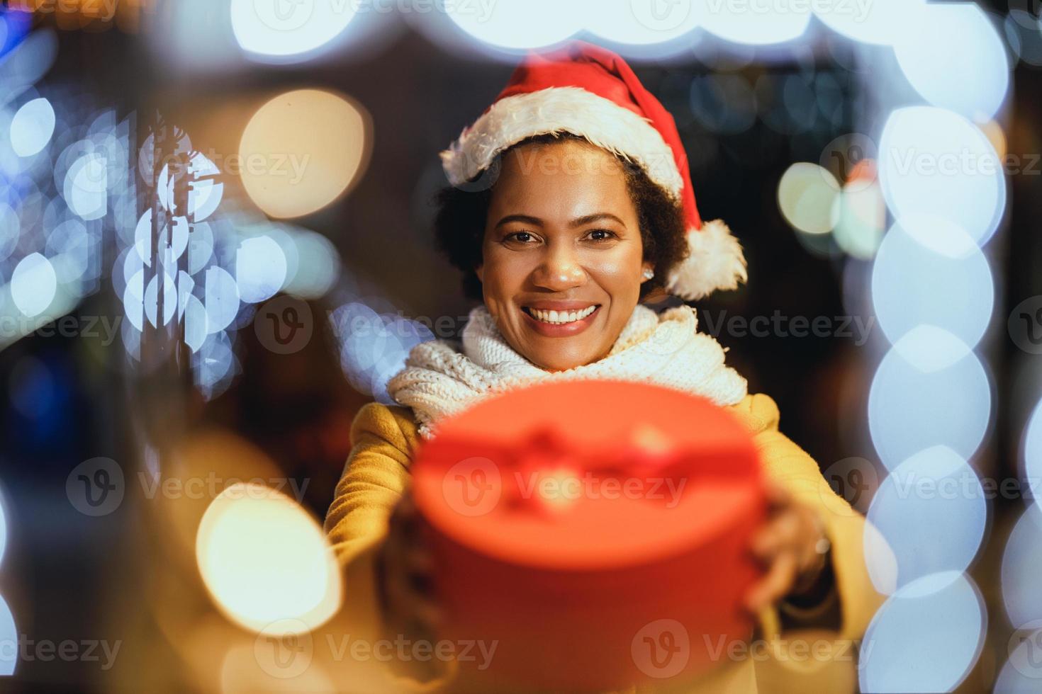 nero donna con rosso natale presente scatola nel il città foto