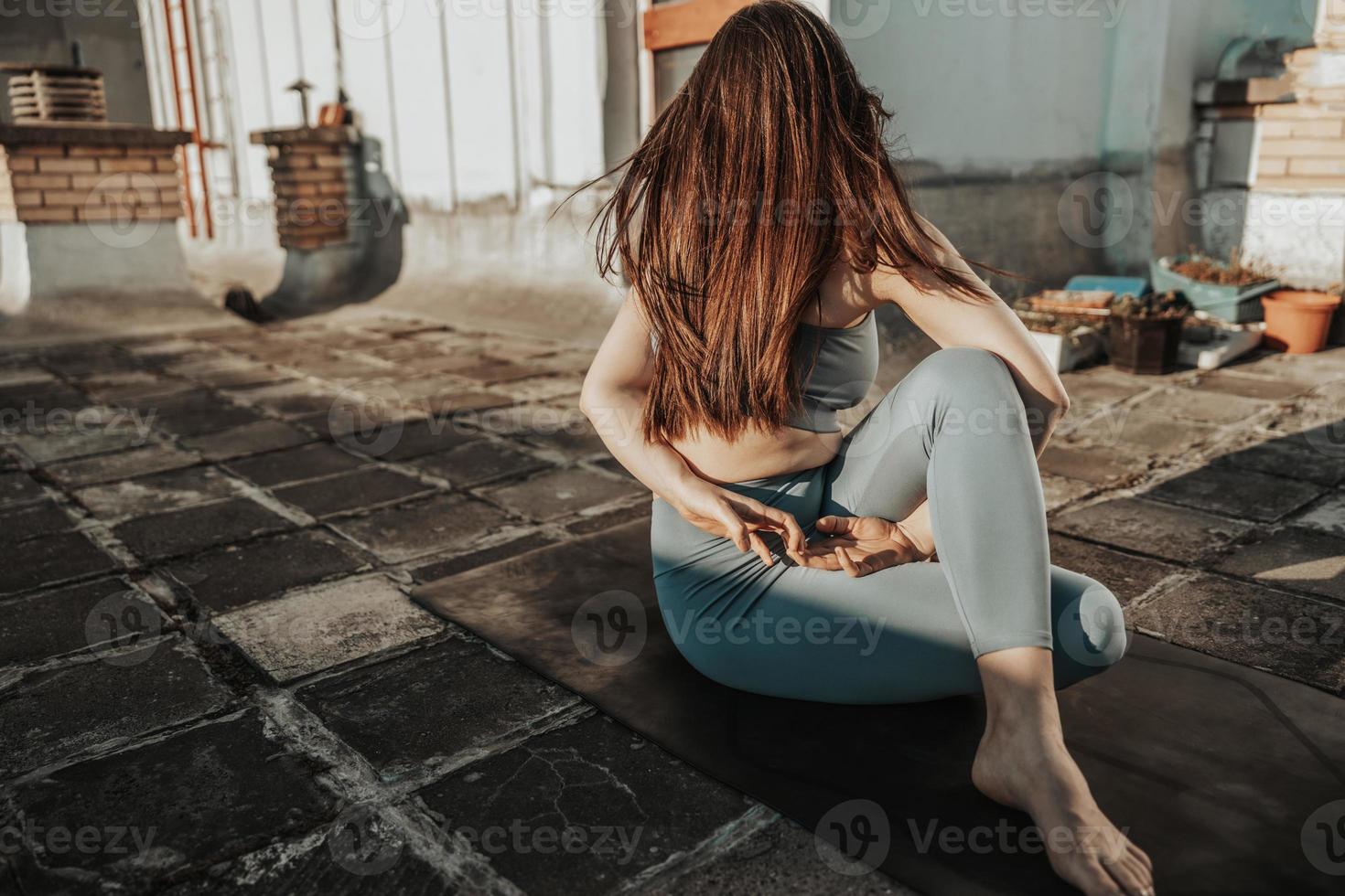 donna fare yoga all'aperto su un' tetto terrazza a tramonto foto