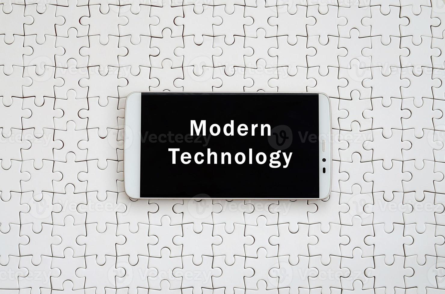 un' moderno grande smartphone con un' toccare schermo bugie su un' bianca sega puzzle nel un assemblato stato con iscrizione. moderno tecnologia foto