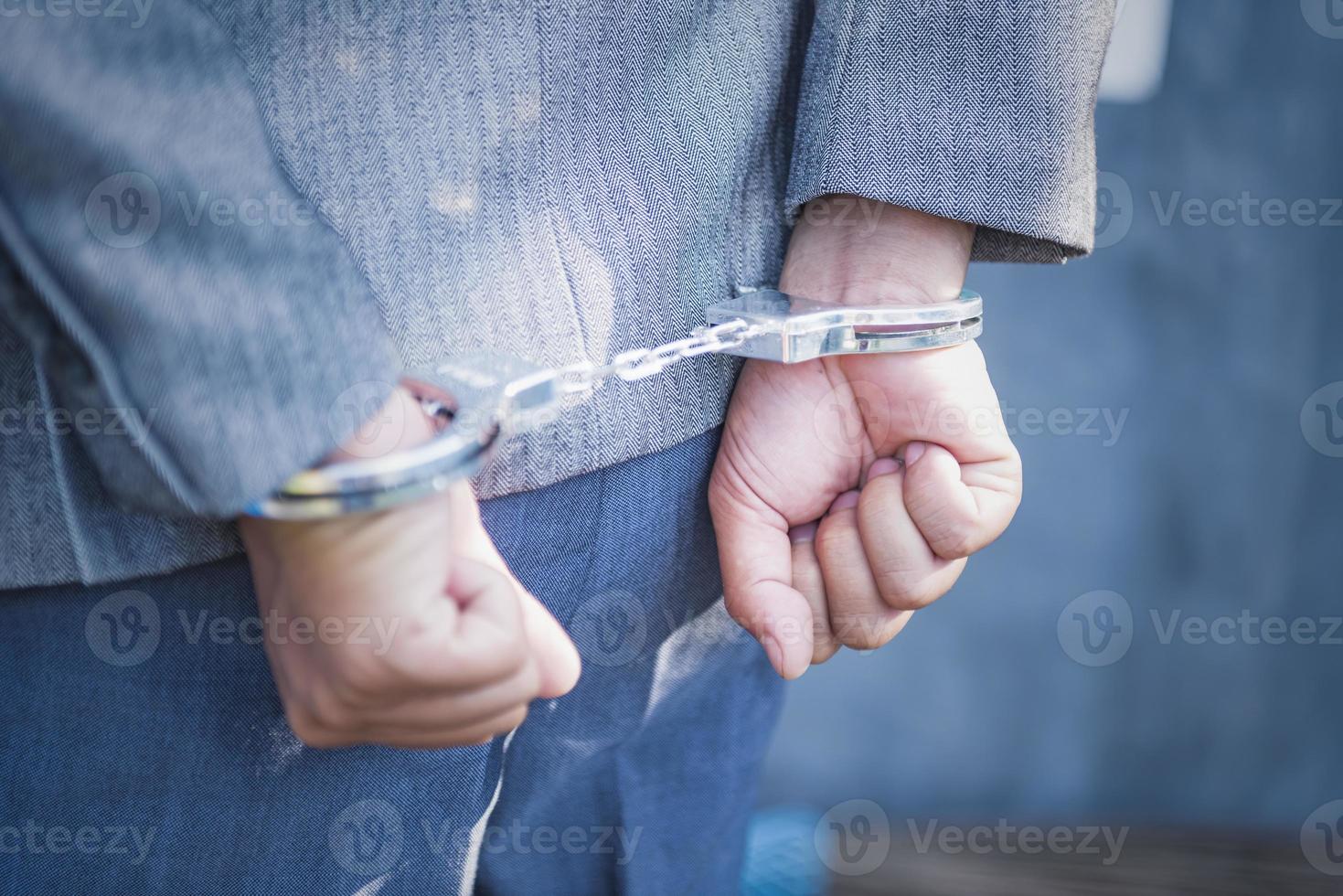 arrestato uomo d'affari nel manette con mani dietro a Indietro. foto