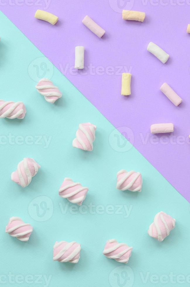 colorato marshmallow di cui su su viola e blu carta sfondo. pastello creativo strutturato modello. minimo foto