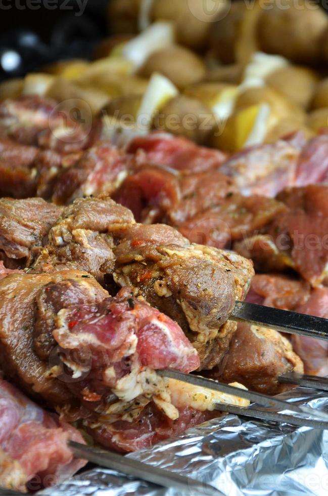 crudo carne e patate siamo piantato su metallo spiedini. il processi di cucinando shish kebab. russo e ucraino campo cibo foto