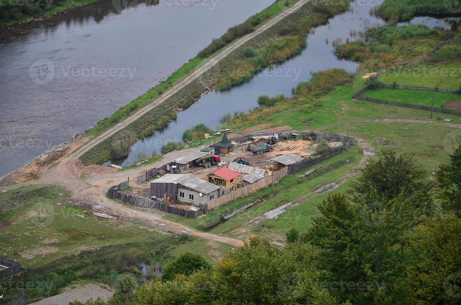 un' bellissimo Visualizza di il villaggio di mezhgorye, carpazi regione. un' lotto di Residenziale edifici circondato di alto foresta montagne e lungo fiume foto