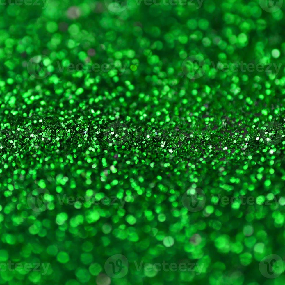 un' enorme quantità di verde decorativo paillettes. sfondo Immagine con brillante bokeh luci a partire dal piccolo elementi foto