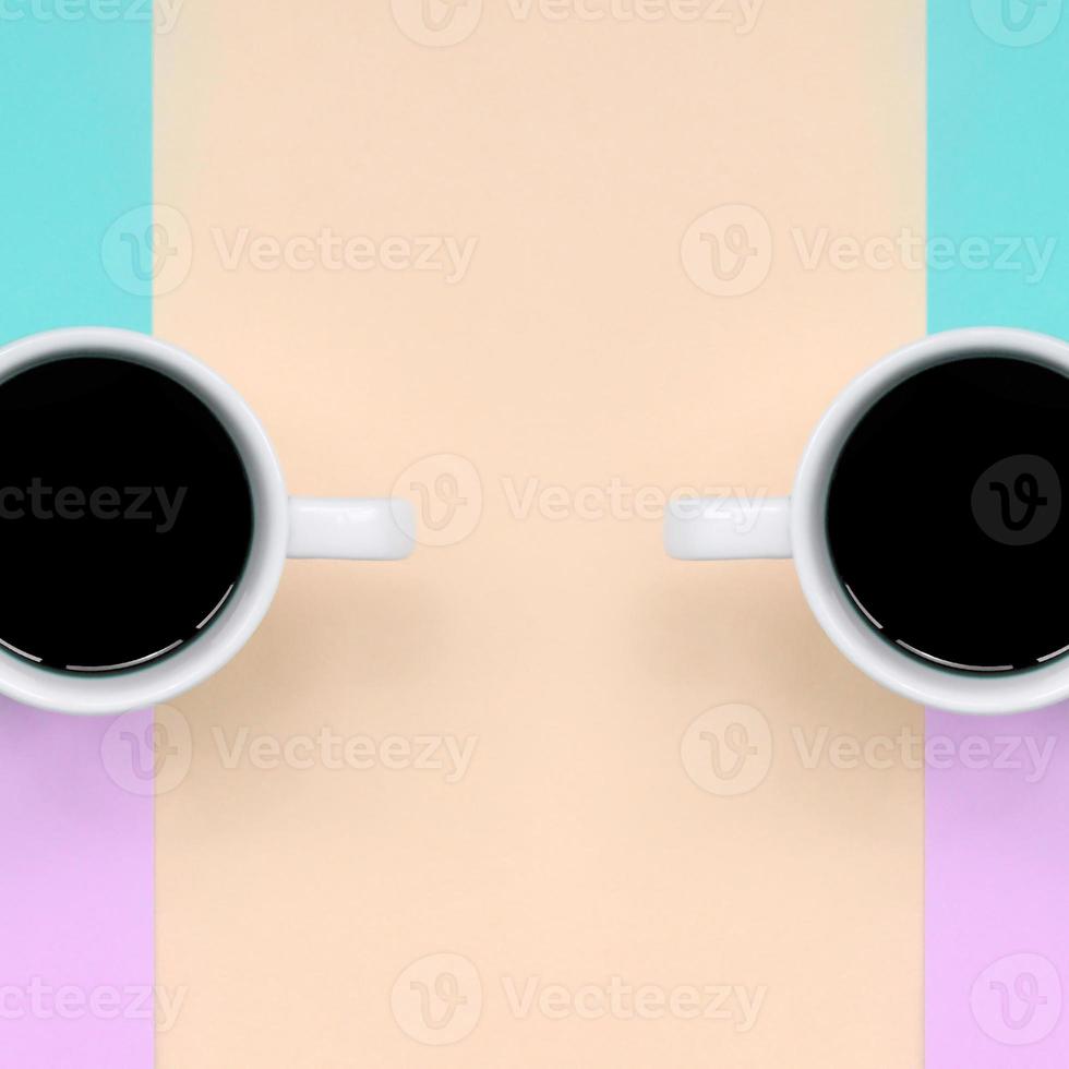 Due piccolo bianca caffè tazze su struttura sfondo di moda pastello rosa, blu, corallo e lime colori carta foto