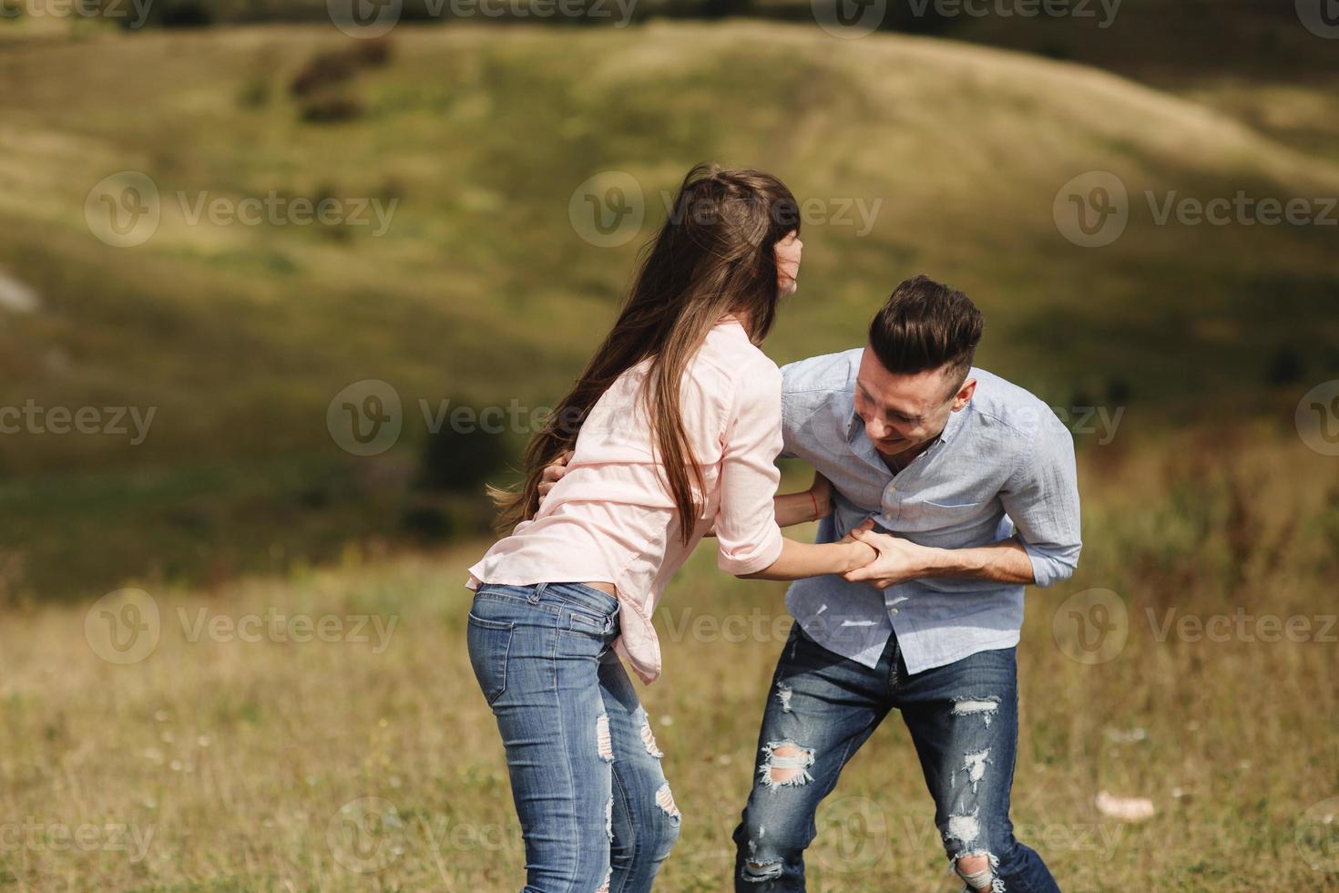 pazza giovane coppia emotivamente divertendosi, baciandosi e abbracciandosi all'aperto. amore e tenerezza, romanticismo, famiglia, emozioni, divertimento. divertirci insieme foto