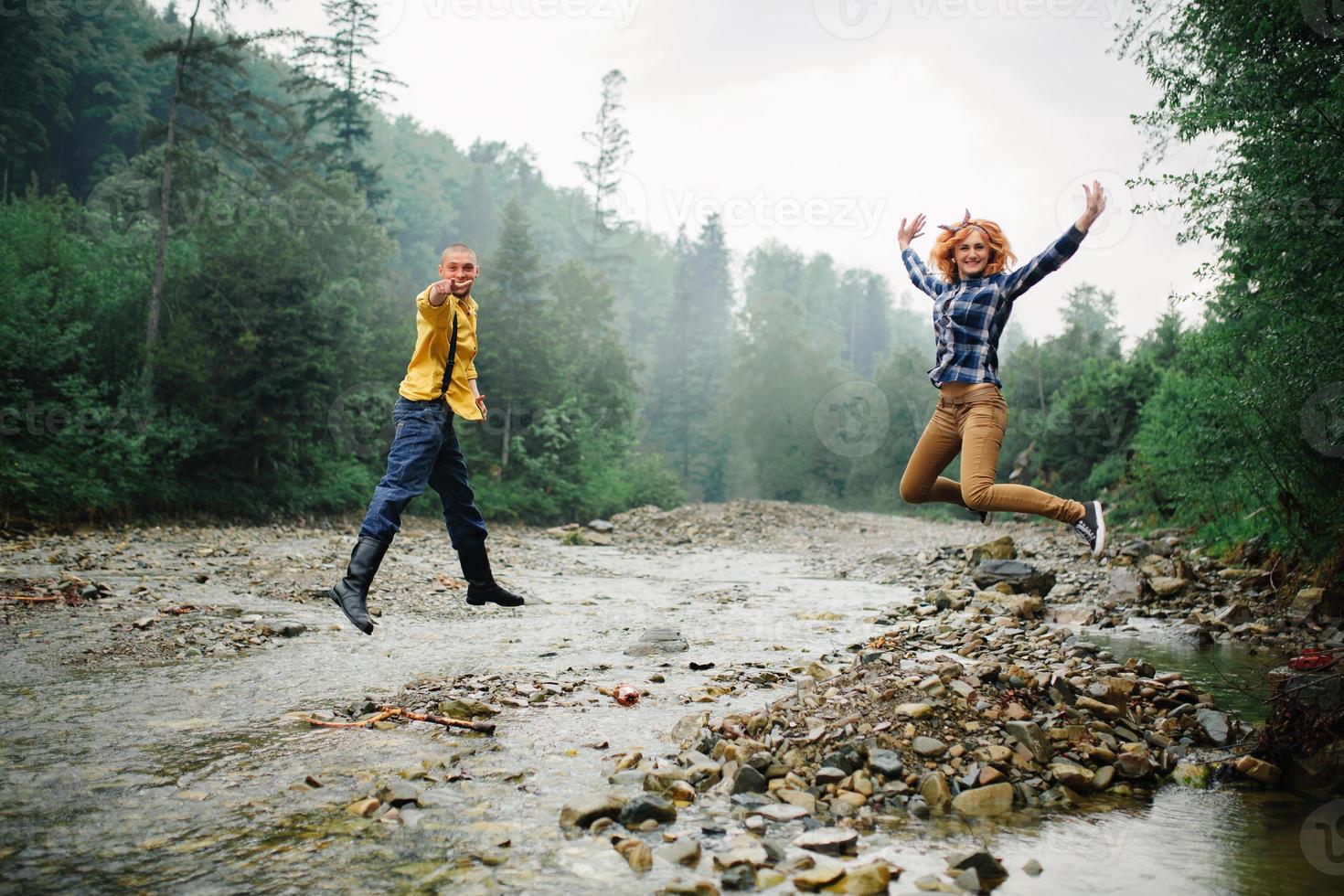 giocoso contento bello coppia avendo mentre a piedi nel boschi. turisti nel il montagne. avventura nel natura concetto. foto
