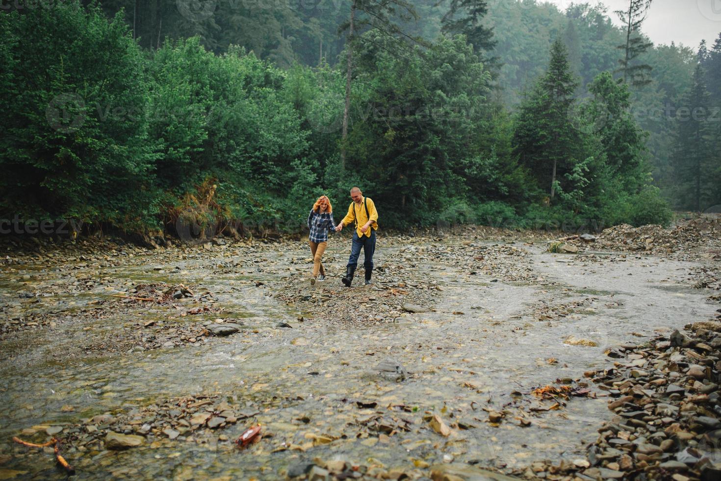 giocoso contento bello coppia avendo mentre a piedi nel boschi. turisti nel il montagne. avventura nel natura concetto. coppia nel il montagne foto