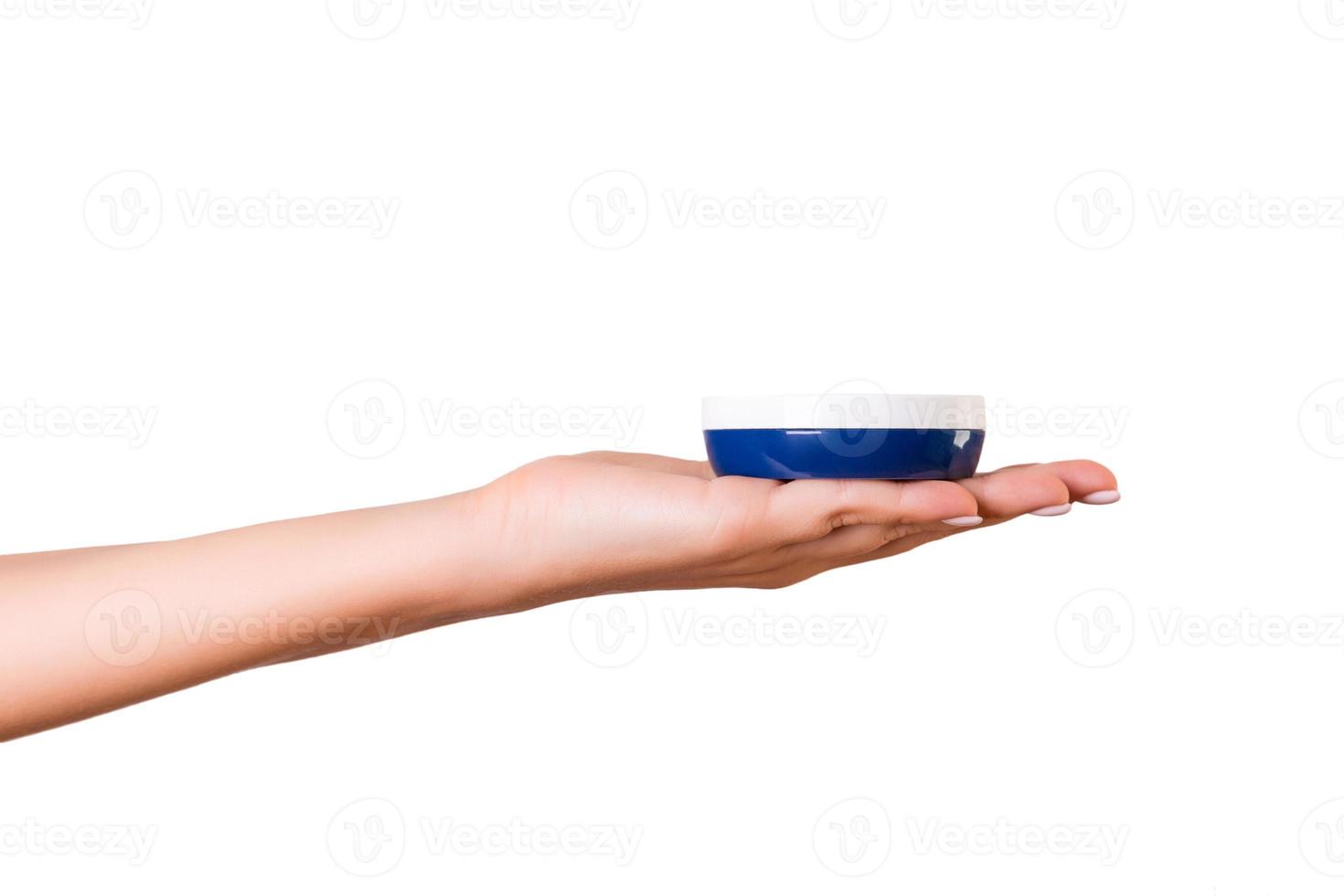 femmina mano Tenere crema bottiglia di lozione isolato. ragazza dare vaso cosmetico prodotti su bianca sfondo foto
