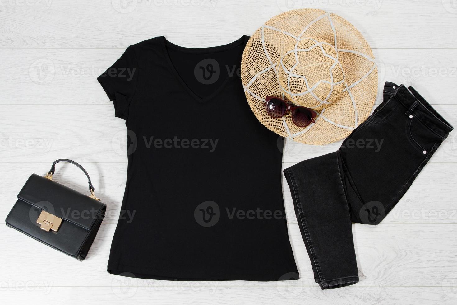 t camicia nero. maglietta modello piatto posare con estate Accessori. cappello, Borsa e occhiali da sole su di legno pavimento sfondo. copia spazio. modello vuoto tela. davanti superiore Visualizza. foto