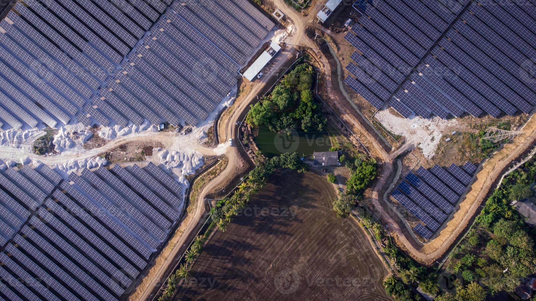 vista aerea di una fattoria solare che produce energia pulita durante la sera. visibile in tutta l'area foto