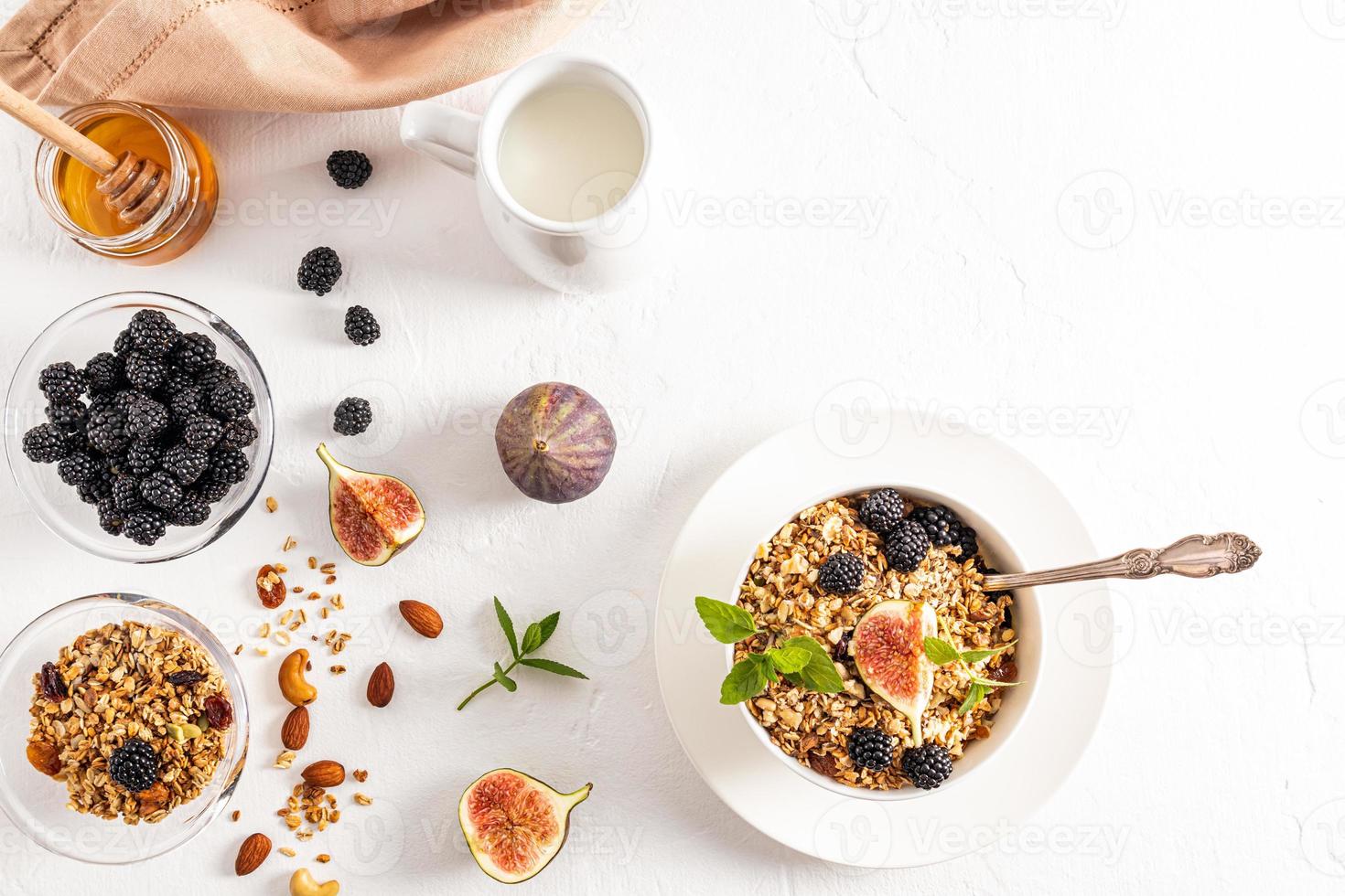 prima colazione per Due. cucinato delizioso muesli nel ceramica ciotole con  noccioline, frutti di bosco, menta e fichi. un' donna di mano detiene un'  cucchiaio di muesli. 13941544 Stock Photo su Vecteezy