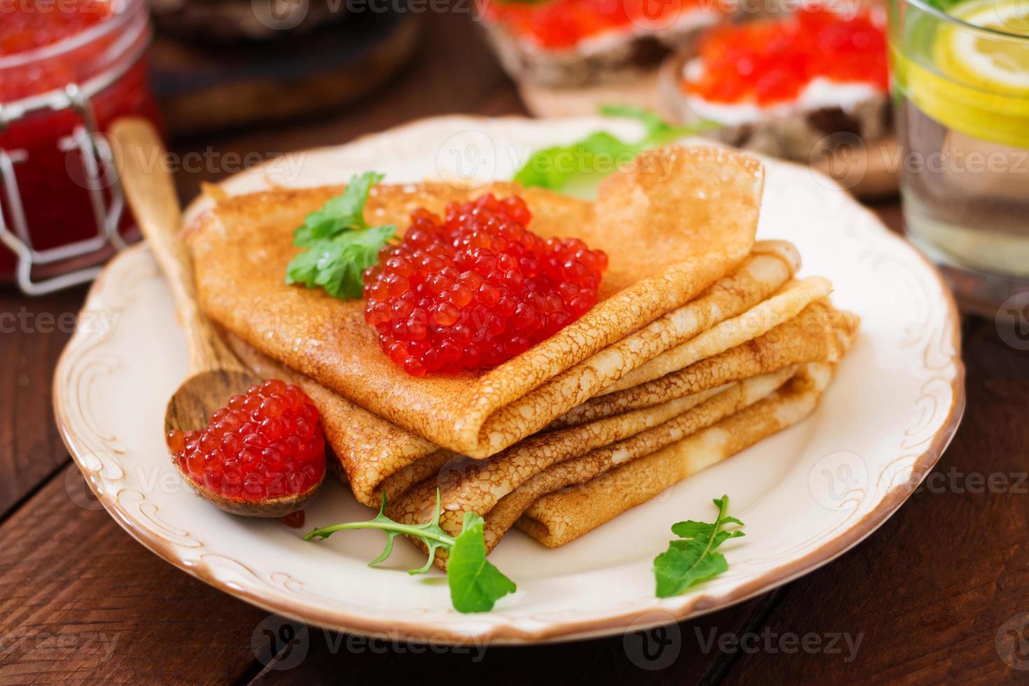 Pancakes con rosso caviale su piatto. russo cucina. maslenitsa foto