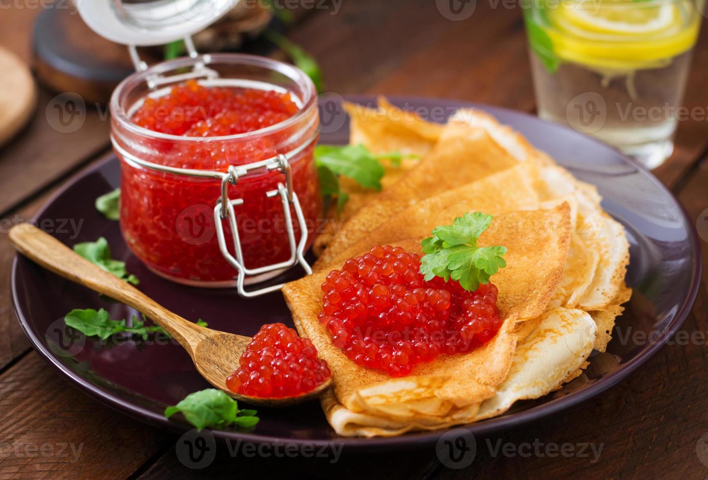 Pancakes con rosso caviale su piatto. russo cucina. maslenitsa foto