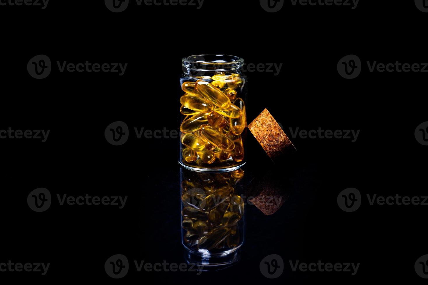 pesce olio capsule. giallo omega 3 pillole nel vaso su il buio nero. pesce olio capsule nel bicchiere di vino bicchiere . nel barattolo. nel secchio fiale foto