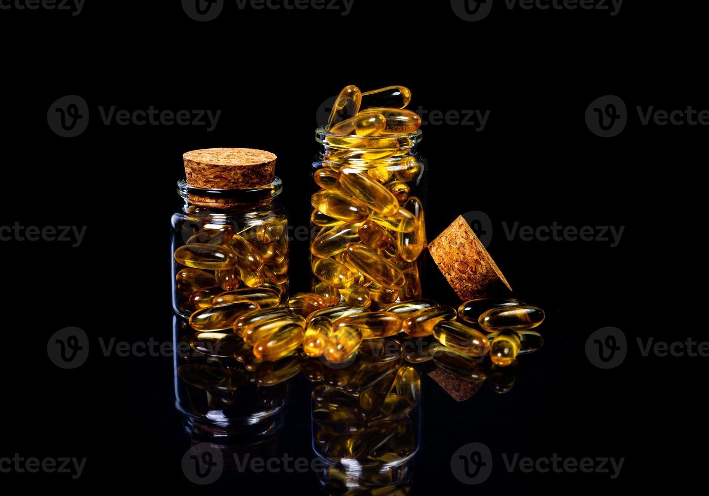 pesce olio capsule. giallo omega 3 pillole nel vaso su il buio nero. pesce olio capsule nel bicchiere di vino bicchiere . nel barattolo. nel secchio fiale foto