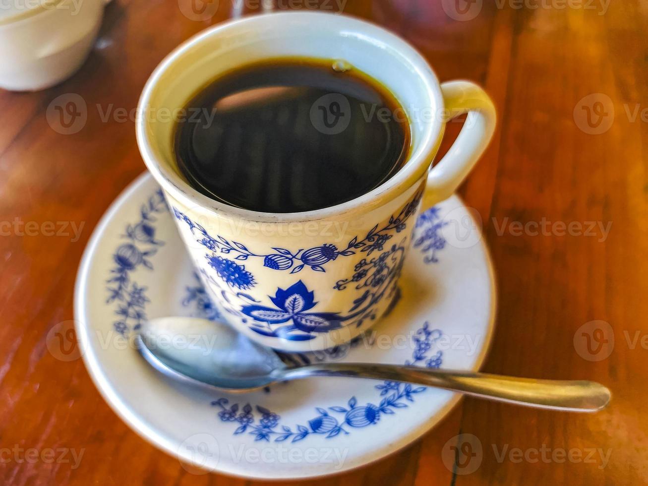 blu bianca tazza pentola con nero caffè di legno tavolo Messico. foto