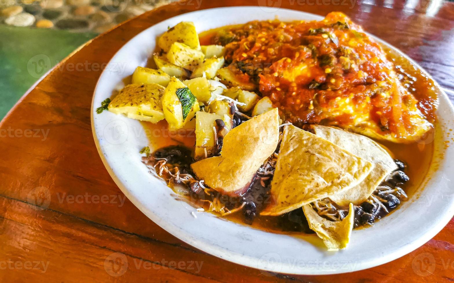 messicano frittata con nero fagioli patate nachos su bianca piatto. foto