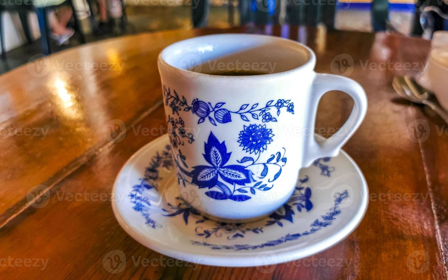 blu bianca tazza pentola con nero caffè di legno tavolo Messico. foto