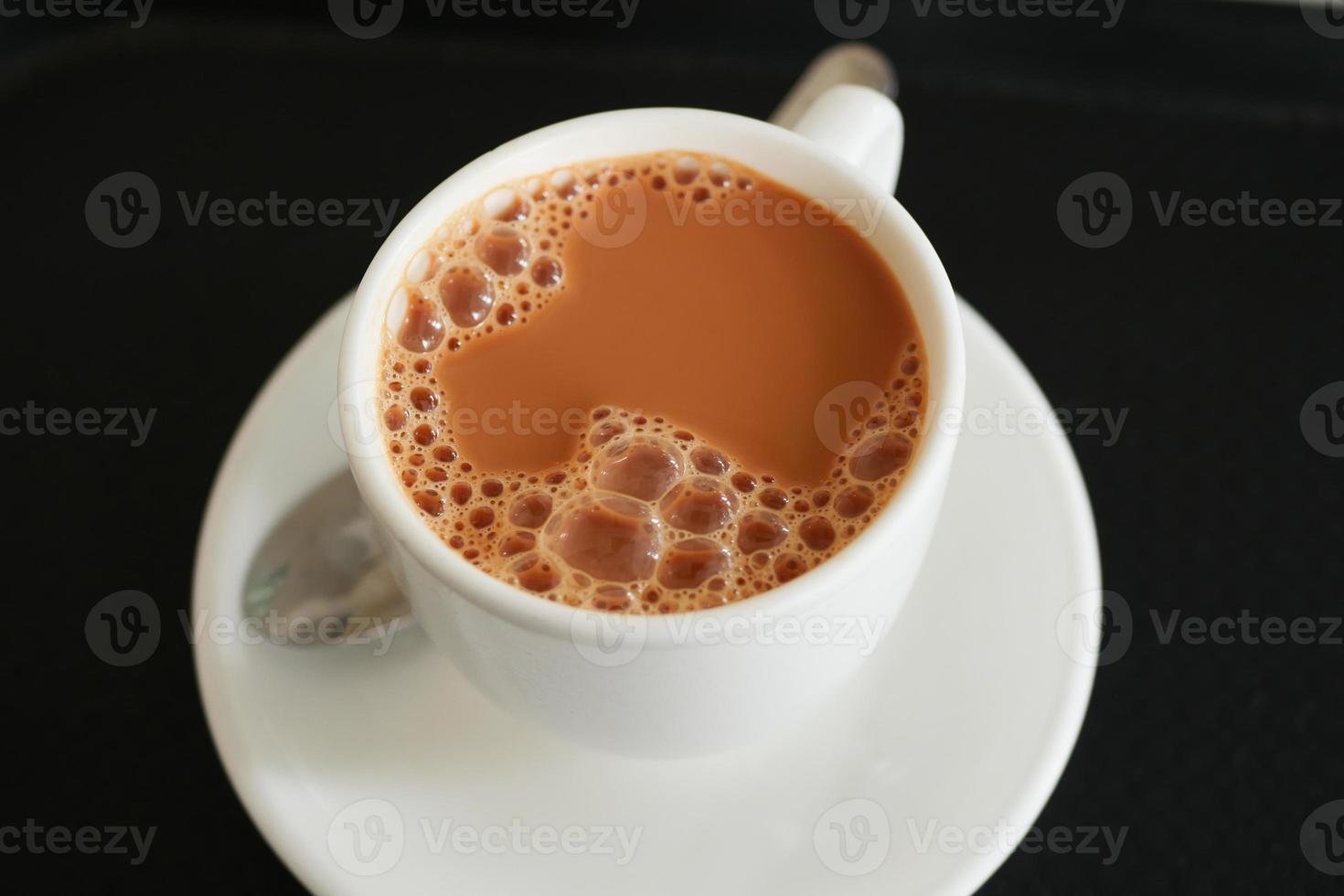 vicino su di tazza di latte tè su tavolo foto