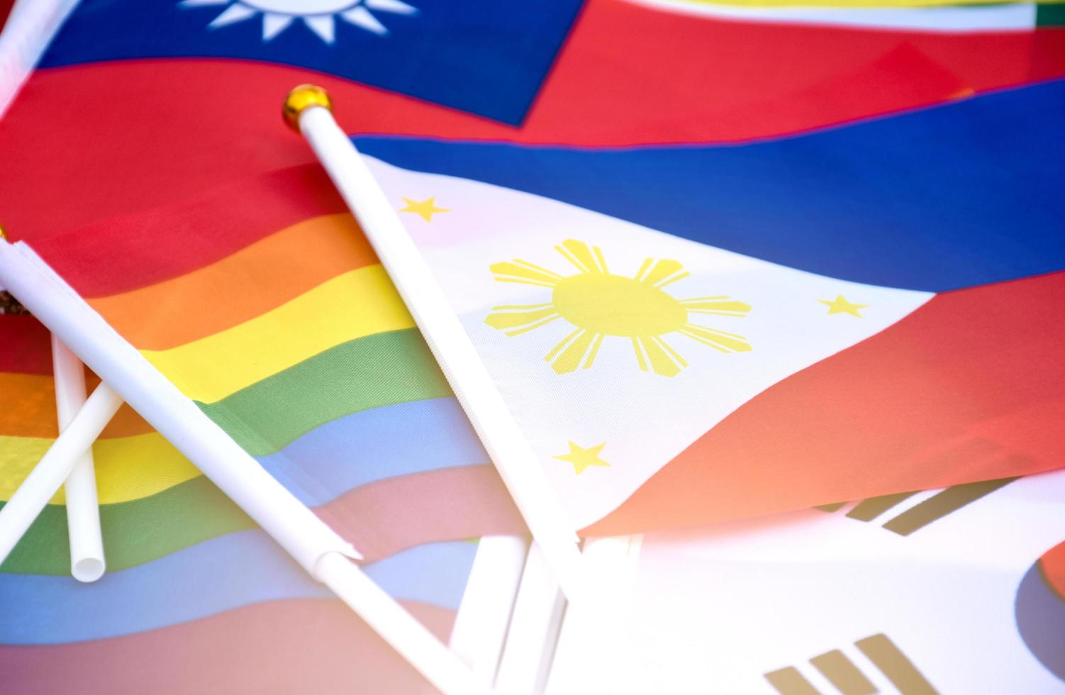 arcobaleno bandiere e bandiere di molti paesi su pavimento, concetto per celebrazione di LGBTQ più generi nel orgoglio mese in giro il mondo, morbido e selettivo messa a fuoco. foto