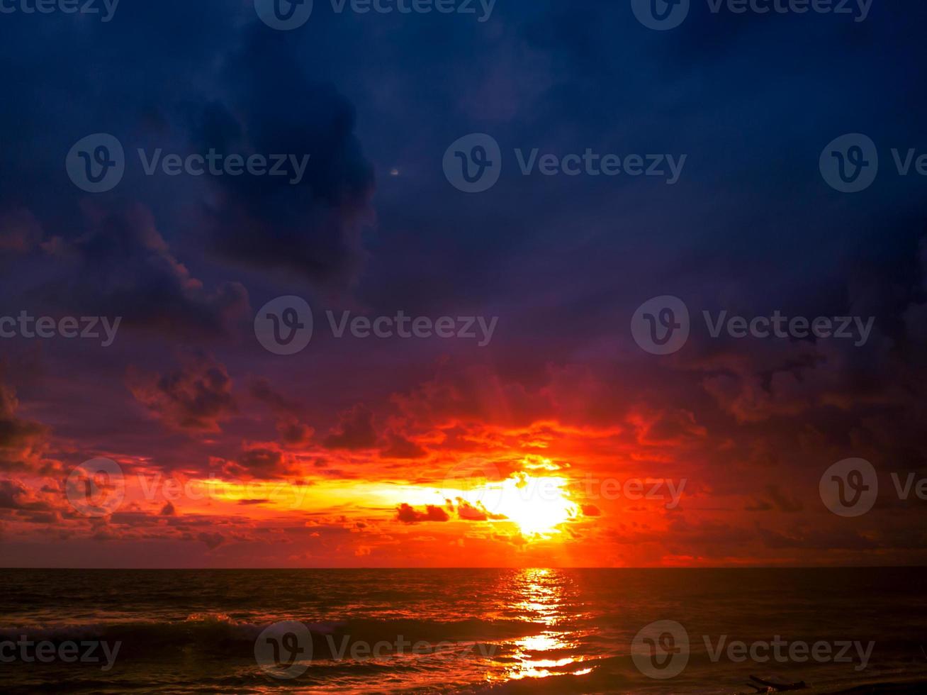 raggiante tramonto al di sopra di oceano riva con colorato cielo foto