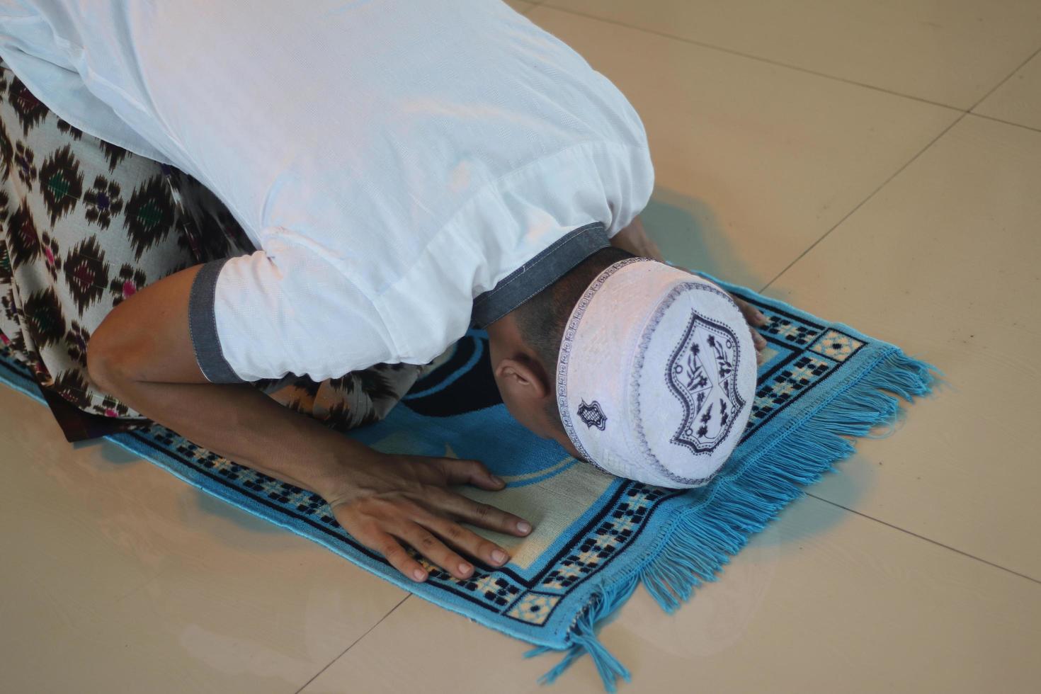 giovane asiatico musulmano preghiere nel il moschea foto