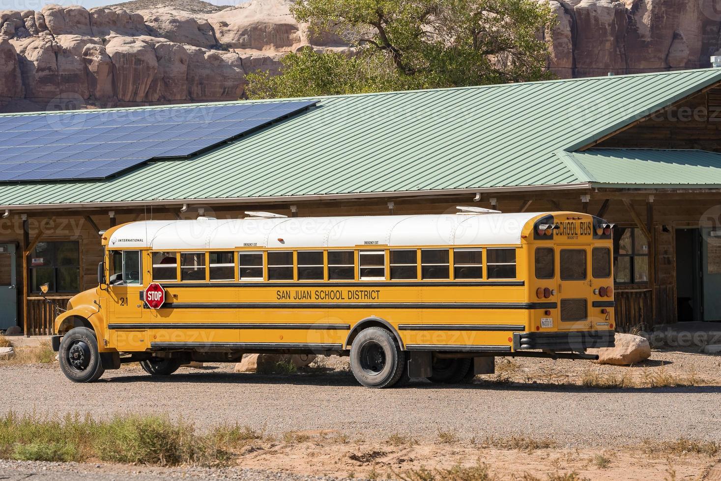 scuola autobus parcheggiata di edificio con solare pannelli su tetto foto