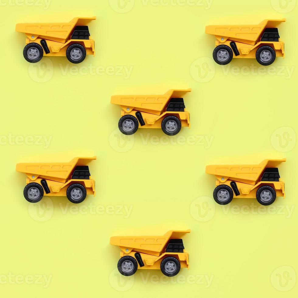 molti piccolo giallo giocattolo camion su struttura sfondo di moda pastello giallo colore carta nel minimo concetto foto