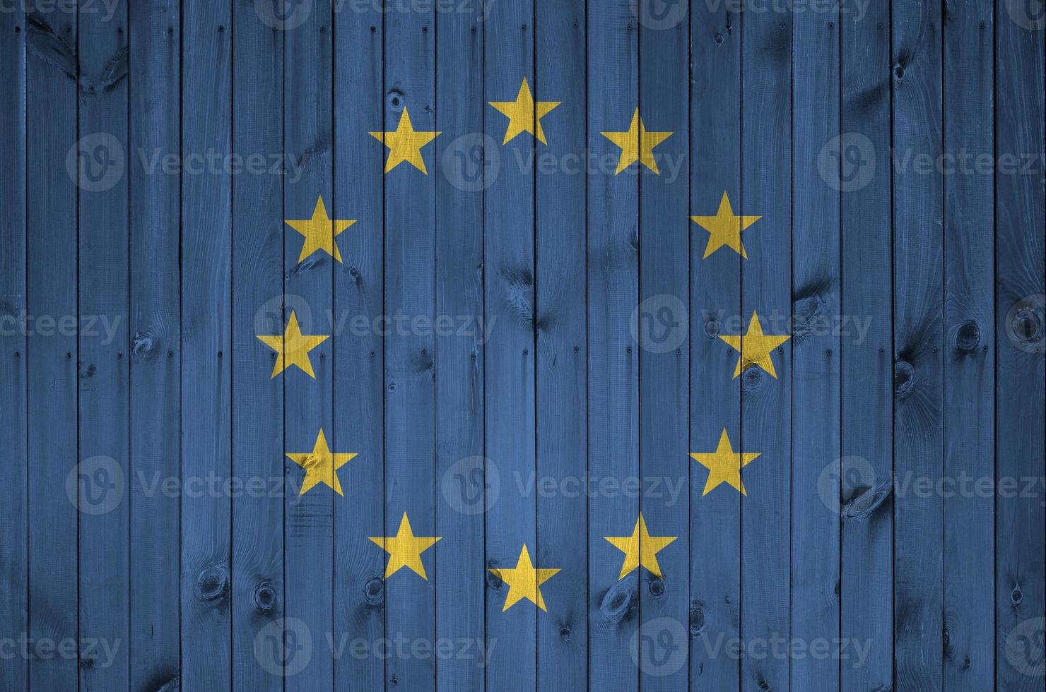 europeo unione bandiera raffigurato nel luminosa dipingere colori su vecchio di legno parete. strutturato bandiera su ruvido sfondo foto