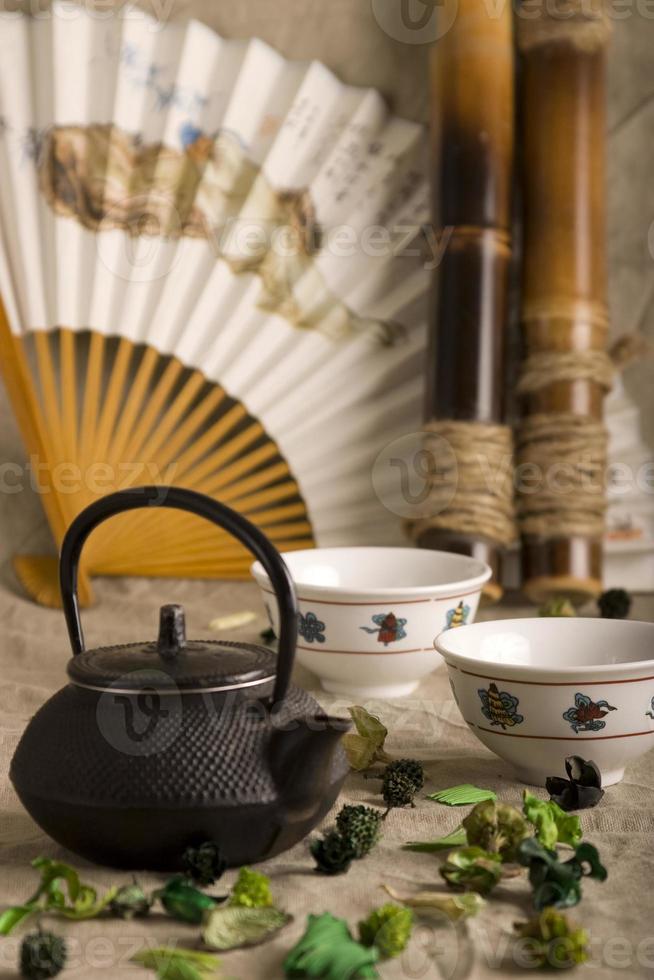 la teiera cinese, due tazze, ventaglio e bambù foto