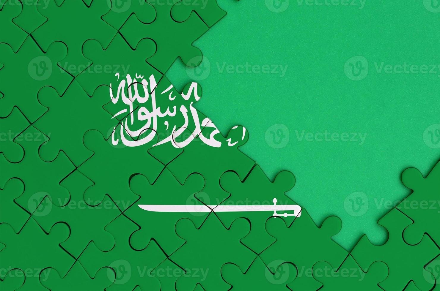 Arabia arabia bandiera è raffigurato su un' completato sega puzzle con gratuito verde copia spazio su il giusto lato foto