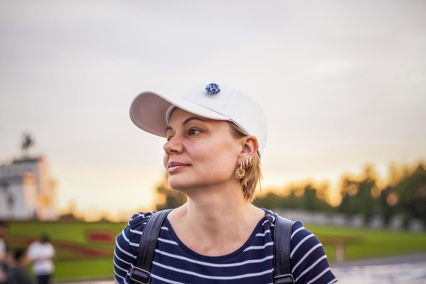 ritratto di un' ragazza nel un' berretto su il sfondo di un aria aperta urbano paesaggio. viaggio. stile di vita nel il città. centro, strade foto