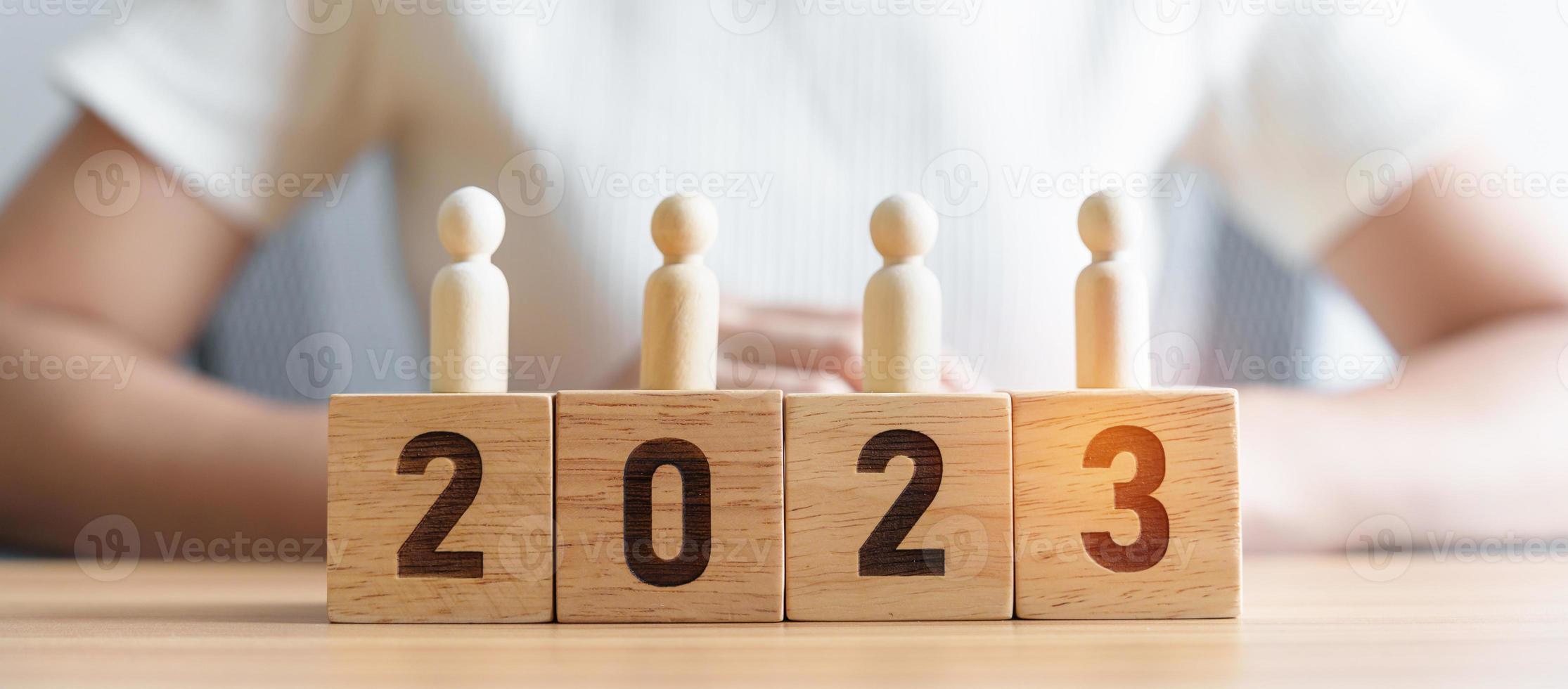 di legno persone in piedi su 2023 anno bloccare. obiettivo, comando, attività commerciale, squadra, lavoro di squadra e nuovo anno risoluzione concetto foto