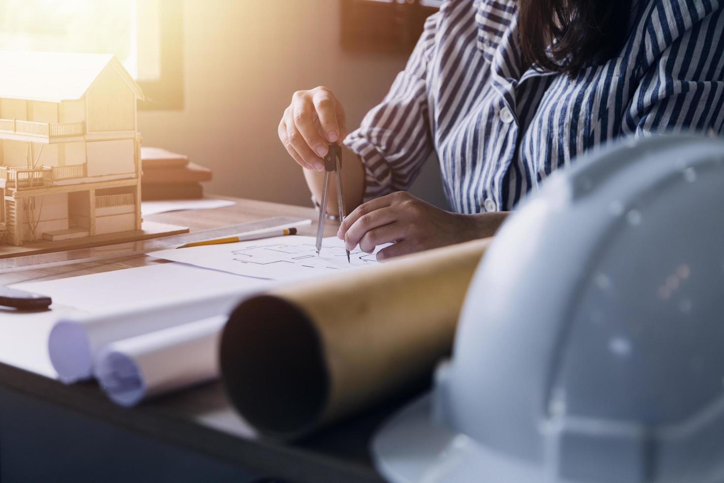 costruzione ingegnere Lavorando a planimetria per costruire grande commerciale edifici nel ufficio. ingegneria utensili e costruzione concetto. foto