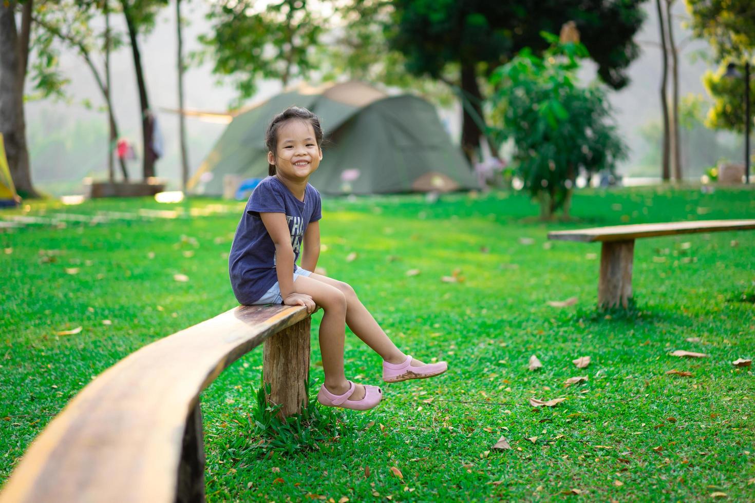 bambina seduta sulla panchina foto