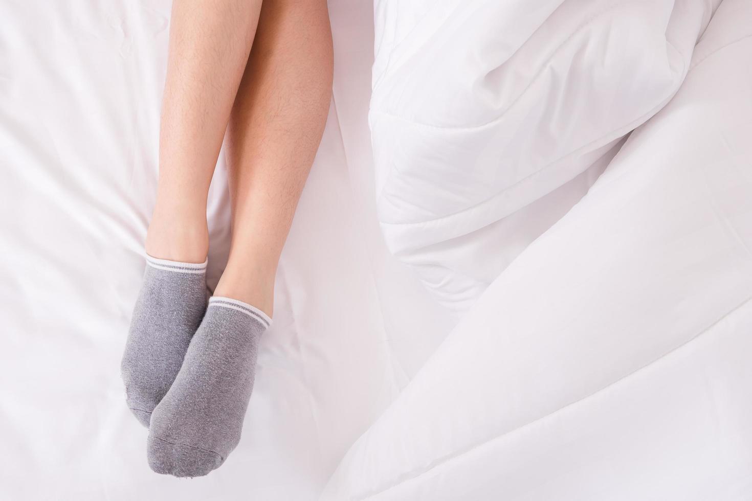 gambe di donne sul letto bianco foto