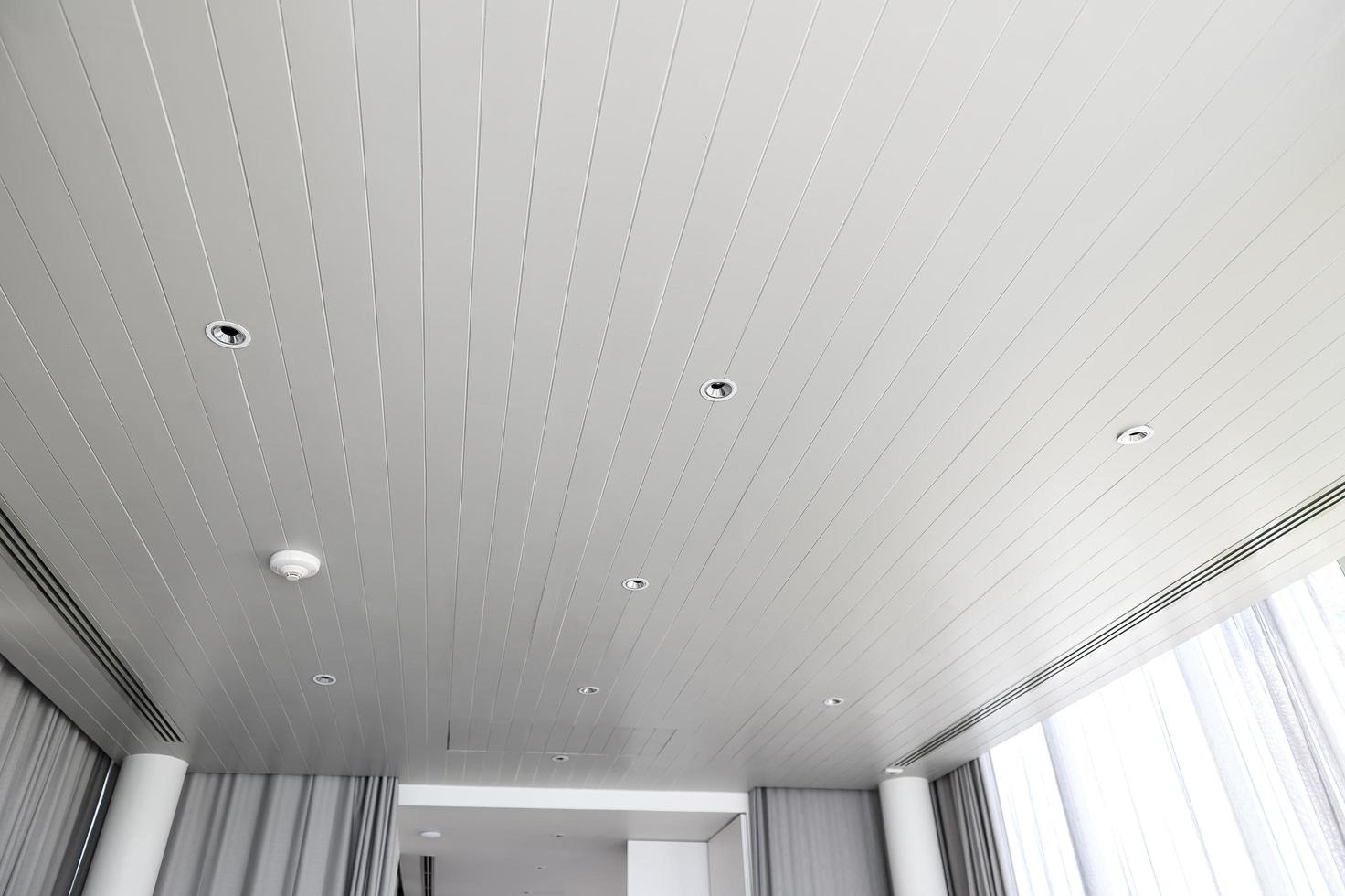 sospeso soffitto con alogeno macchie lampade e cartongesso costruzione nel vuoto camera nel appartamento o Casa. allungare soffitto bianca e complesso forma foto